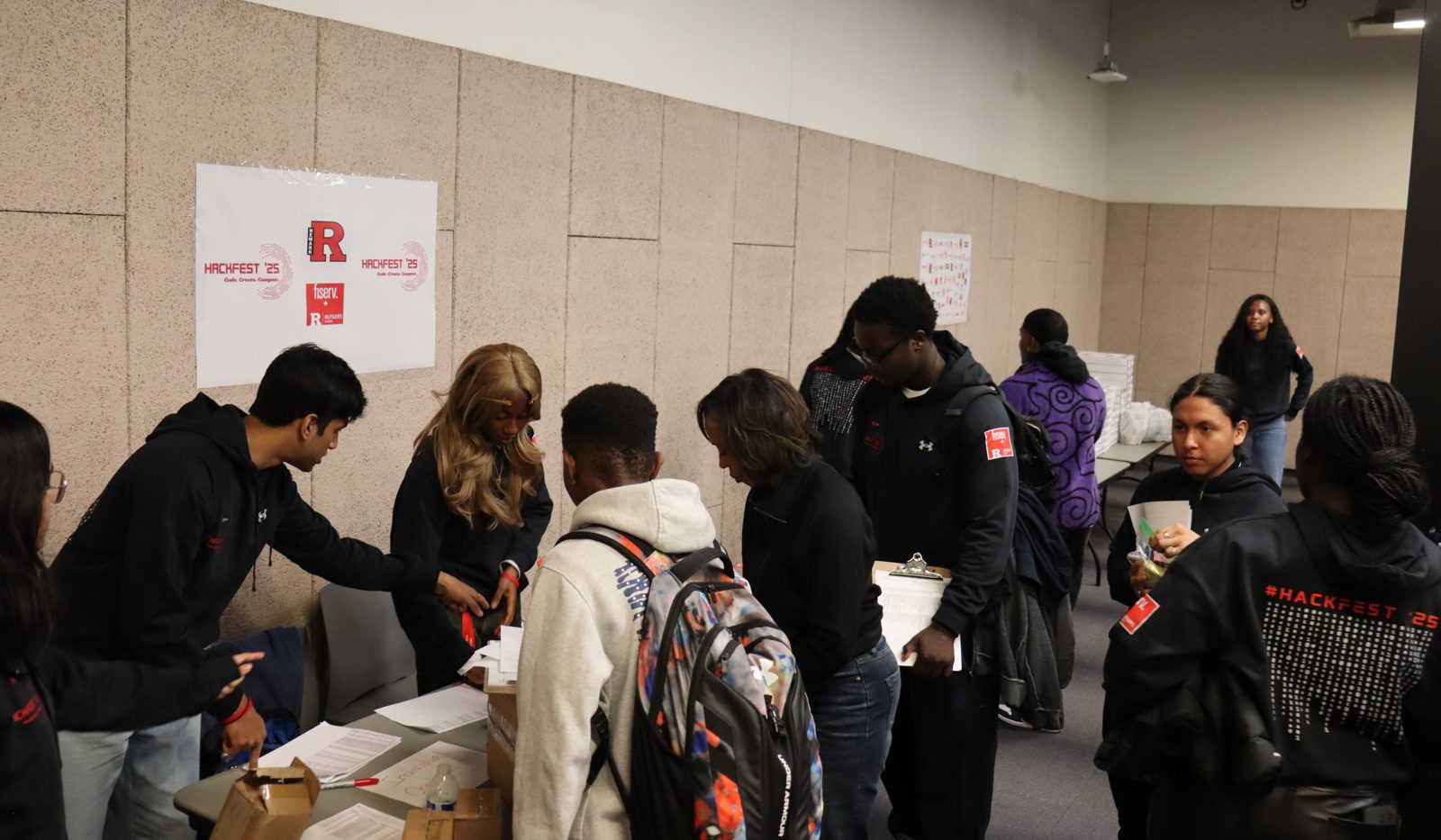 Students checking in together at HackFest 2025, beside a HackFest ’25 poster.